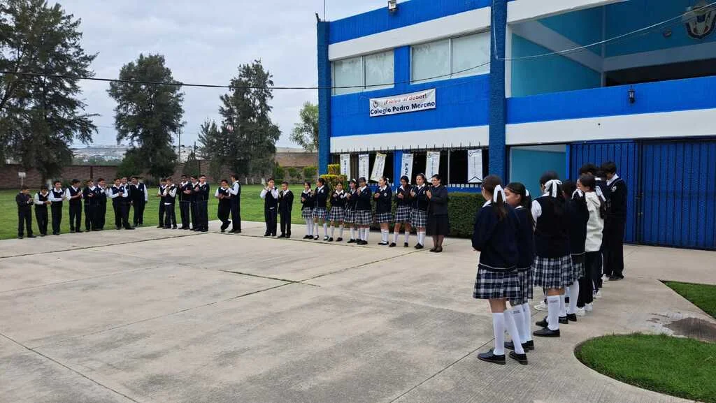 Estudiantes uniformados reunidos en el patio frente al edificio del Colegio Pedro Moreno.